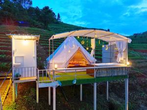 a tent with a bed in a field at มายด์โฮมสเตย์ in Mon Jam