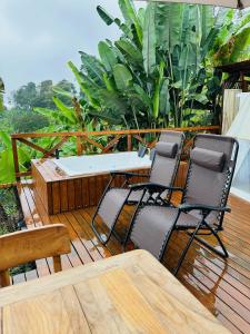 2 chaises et une table sur une terrasse en bois dans l'établissement Eco Glamping Cordillera, à Buenavista