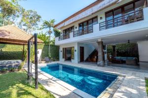 a villa with a swimming pool and a house at Kecapi Villa Seminyak by Ini Vie Hospitality in Seminyak