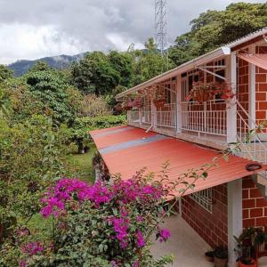 a balcony of a house with pink flowers at La Ramada Campestre in Calarcá