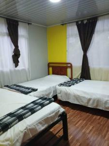 a room with three beds in a room at La Ramada Campestre in Calarcá