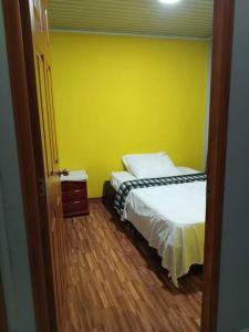 a bedroom with two beds and a yellow wall at La Ramada Campestre in Calarcá