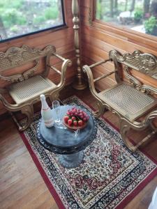 a room with two chairs and a table with fruit on it at Routemaster in Gramado