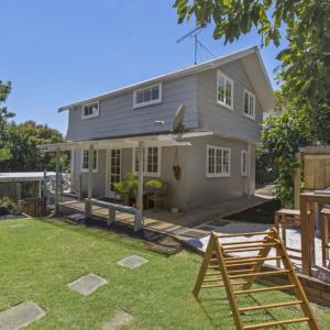 a small house with a yard with a yard at Abbeygate Cottage in Auckland