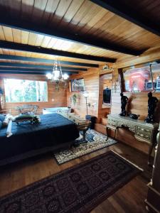 um quarto com uma cama grande num quarto com paredes de madeira em Routemaster em Gramado