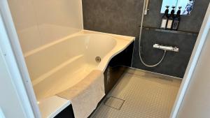 un bagno con vasca e lavandino di 加美屋リゾート ひたち大洗オーシャンテラス-Kamiya Resort Hitachi Oarai Ocean Terrace a Nakaminato