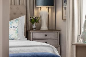 a bedroom with a bed with a lamp and a dresser at Hamilton Turner Inn in Savannah