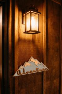 a light on a wall with a table with a lamp at Treehouse Cozy Glamping Site in Branson