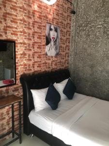 Cama en habitación con pared de ladrillo en Bluemoon 10 guests Home en Ko Samed