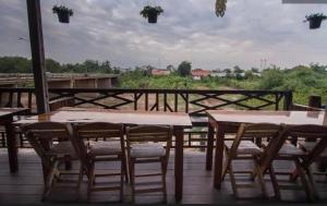 eine Gruppe von Tischen und Stühlen auf einer Terrasse in der Unterkunft โรงแรมริเวอร์เลย แกรนด์วิว in Wang Saphung