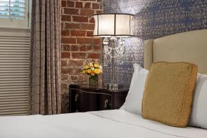 a bedroom with a bed and a brick wall at Hamilton Turner Inn in Savannah