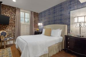 a bedroom with a bed and a brick wall at Hamilton Turner Inn in Savannah