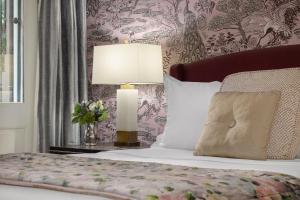 a bedroom with a bed with a lamp and flowers at Hamilton Turner Inn in Savannah