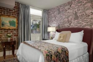 a bedroom with a bed and a brick wall at Hamilton Turner Inn in Savannah