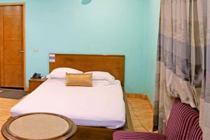 um quarto com uma cama branca e uma cabeceira em madeira em Shaira Garden Hotel & Resorts em Nārāyanganj