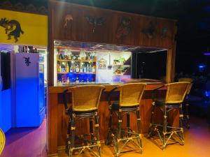 eine Bar mit vier Stühlen vor einem Kühlschrank in der Unterkunft Krabi Villa Phu Khao Private Resort in Klong Muang Beach
