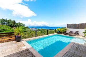 a pool with a view of the ocean from a house at la villa Mareva in Faaa