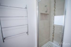 a bathroom with a shower with a glass door at Victorian Goldfields Cottage in Ballarat