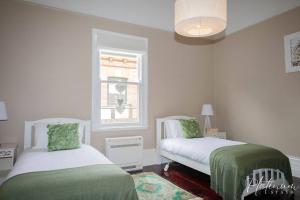 1 dormitorio con 2 camas y ventana en Victorian Goldfields Cottage en Ballarat