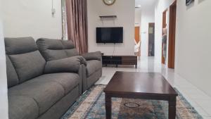 a living room with a couch and a coffee table at Anjung KLIA House 01 With Neflix & Airport Shuttle in Banting