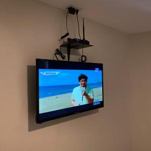 einen Flachbild-TV, der an einer Wand hängt in der Unterkunft Suntal Residences in Bacolod City