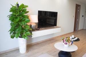 a living room with a plant in a white vase at Apartment Scenic Valley Quận 7 in Ho Chi Minh City