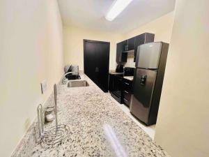 a kitchen with a refrigerator and a counter top at Business Stay 2-BR Apartment in Centro Morazán in Tegucigalpa