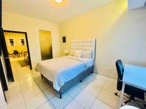a bedroom with a bed and a table and a desk at Business Stay 2-BR Apartment in Centro Morazán in Tegucigalpa
