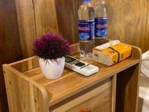 a wooden cabinet with two bottles of water and a plant at Hồng Gấm Homestay in Bak Kan