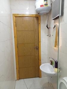 a bathroom with a wooden door and a sink at Golden pyramids view in Cairo