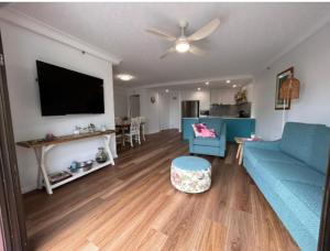 a living room with a blue couch and a flat screen tv at Royal Palm Resort on the Beach in Gold Coast