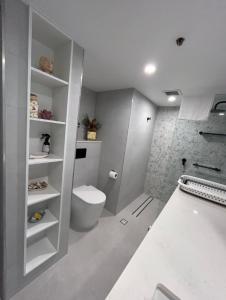 a white bathroom with a toilet and a bath tub at Royal Palm Resort on the Beach in Gold Coast
