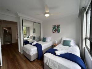 a bedroom with two beds with blue and white sheets at Royal Palm Resort on the Beach in Gold Coast