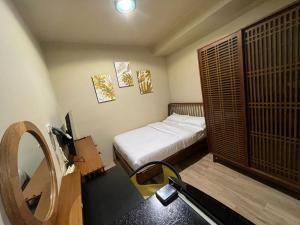 - une petite chambre avec un lit et un miroir dans l'établissement Choska Residence, à Jakarta