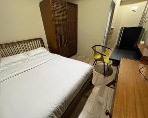 um quarto com uma cama, uma secretária e uma cadeira em Choska Residence em Jakarta