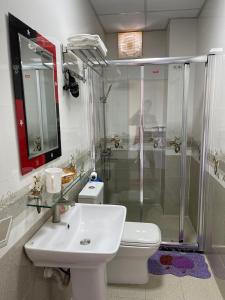 a bathroom with a shower and a toilet and a sink at Cat Ba Central Homestay in Cat Ba