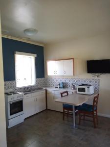 a small kitchen with a table and a microwave at Lakes Entrance Waterfront Cottages with King Beds in Lakes Entrance