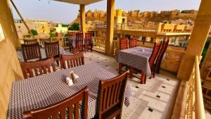 un restaurante con mesas y sillas en un balcón en Royal Villa Jaisalmer, en Jaisalmer