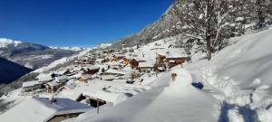 Ski Chalet - Chez Helene Ski fb في Montagny: قرية مغطاة بالثلج على جبل