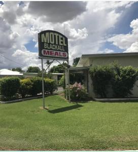 una señal de motel frente a un edificio en Motel Blackall, en Blackall