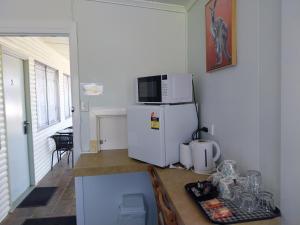 a kitchen with a white refrigerator and a microwave at Motel Blackall in Blackall