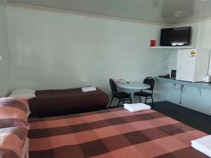 a room with a bed and a table with chairs at Motel Blackall in Blackall