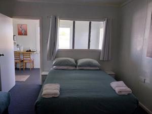 um quarto com uma cama com duas almofadas e uma janela em Motel Blackall em Blackall