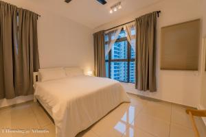 ein Schlafzimmer mit einem Bett und einem großen Fenster in der Unterkunft Atlantis Executive Melaka By I Housing in Malakka + 133 Fotos
