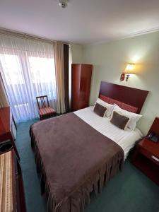 ブハラにあるInturist Hotel Classic Grand Bukharaの大型ベッドとテレビが備わるホテルルームです。