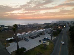 a building with a parking lot next to the ocean at Sea Breeze Inn - San Simeon in San Simeon