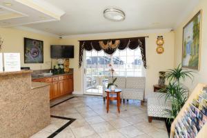 a living room with a table and a large window at Sea Breeze Inn - San Simeon in San Simeon