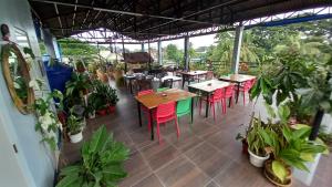 un restaurante con mesas, sillas y plantas en Keen's Place en Puerto Princesa