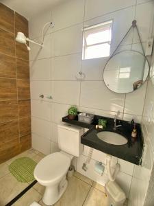 uma casa de banho com um WC, um lavatório e um espelho. em POUSADA ALLES em Santo Amaro