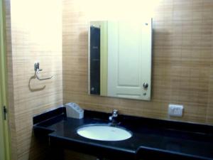 a bathroom with a sink and a mirror at Infinity Lake View Studio in Lavasa